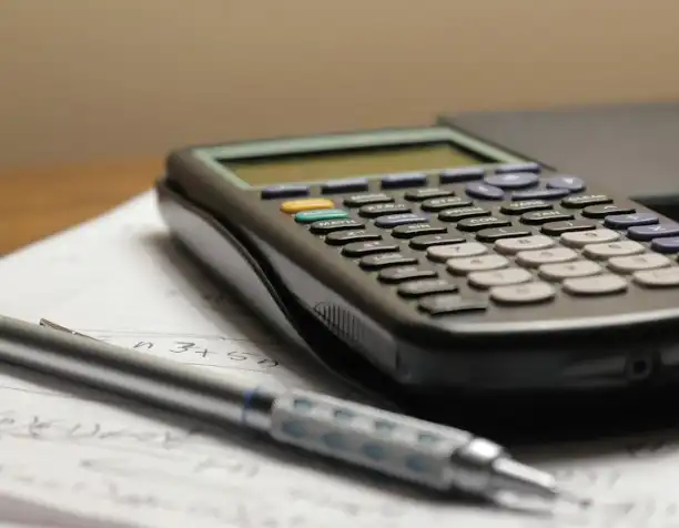 A calculator and a pen on paper