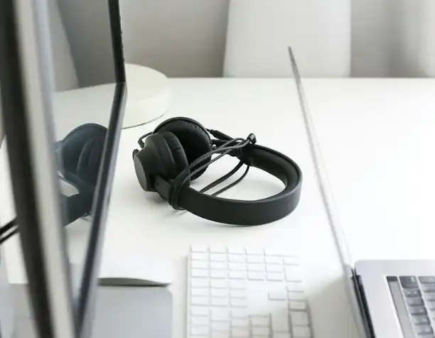 Headphones on a desk next to a keyboard