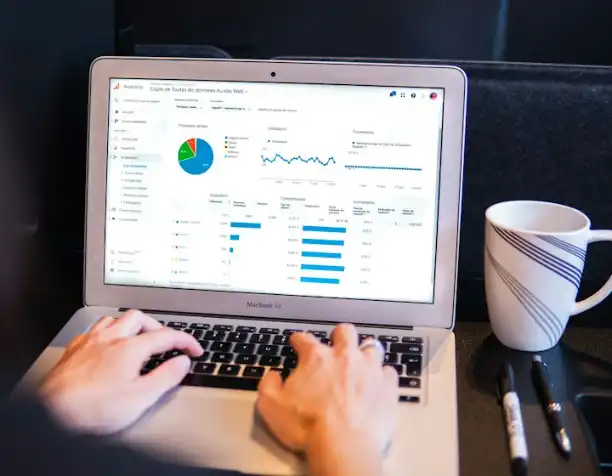 Hands on a laptop showing charts