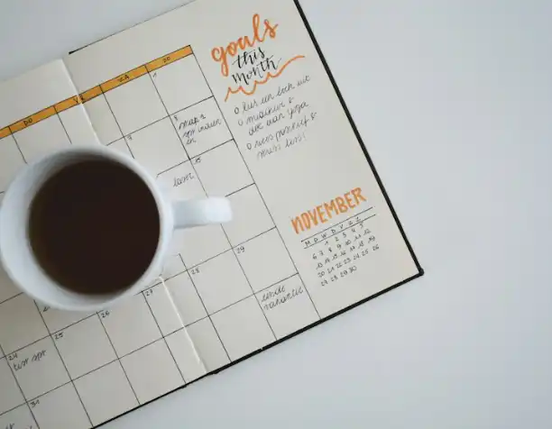 A planner and a cup of coffee on a desk